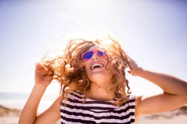 Je prépare mes cheveux pour l'été Une femme profite du soleil sur une plage