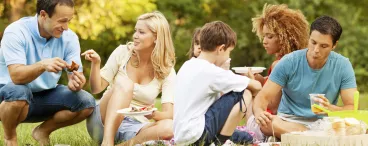 Un groupe de gens partagent un pique-nique dans un parc.