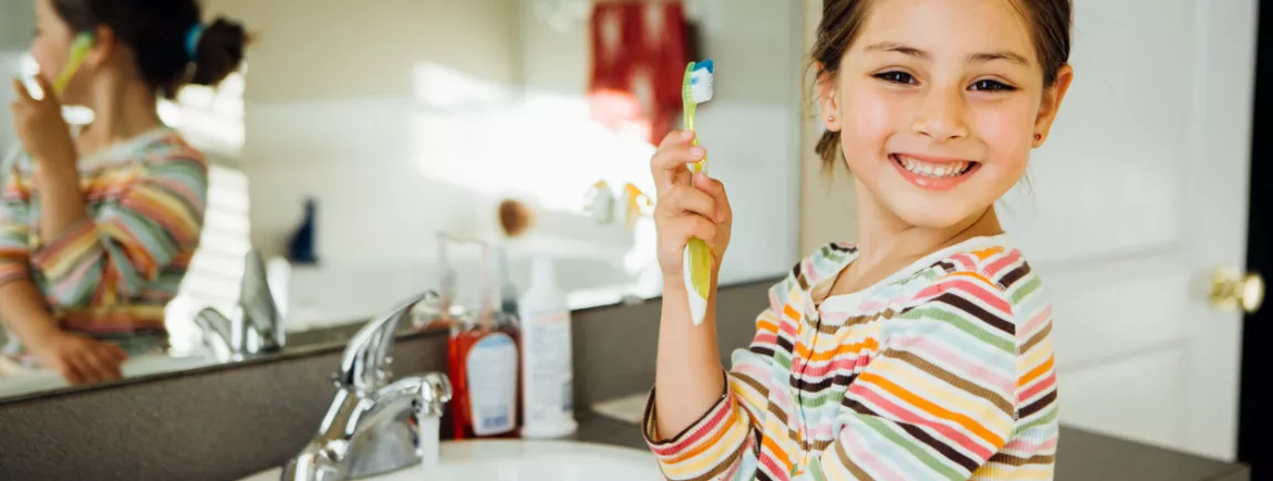10 choses à savoir sur le brossage de dents de vos enfants Fillette montrant sa brosse à dent