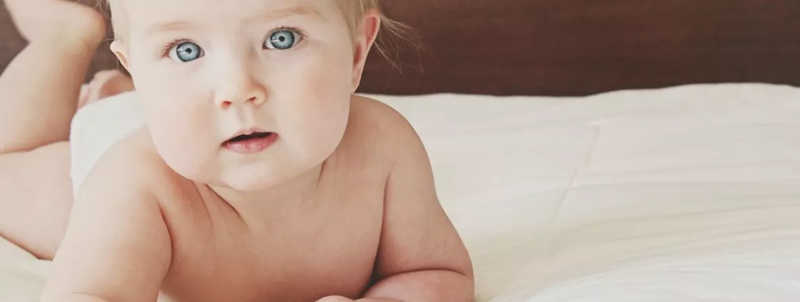 Optons pour une lessive adaptée à la peau des bébés Un bébé à plat ventre sur un lit