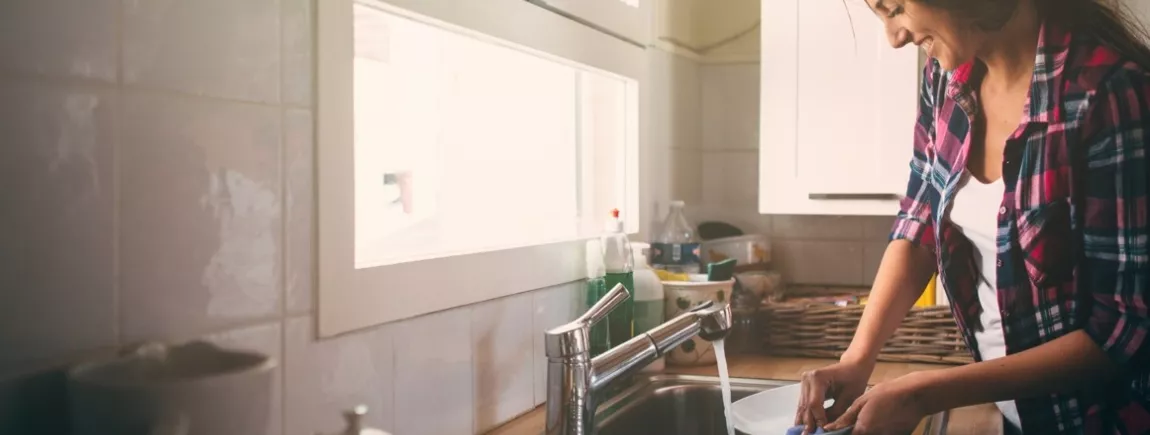 Maison propre, vacances zen Une femme fait la vaisselle